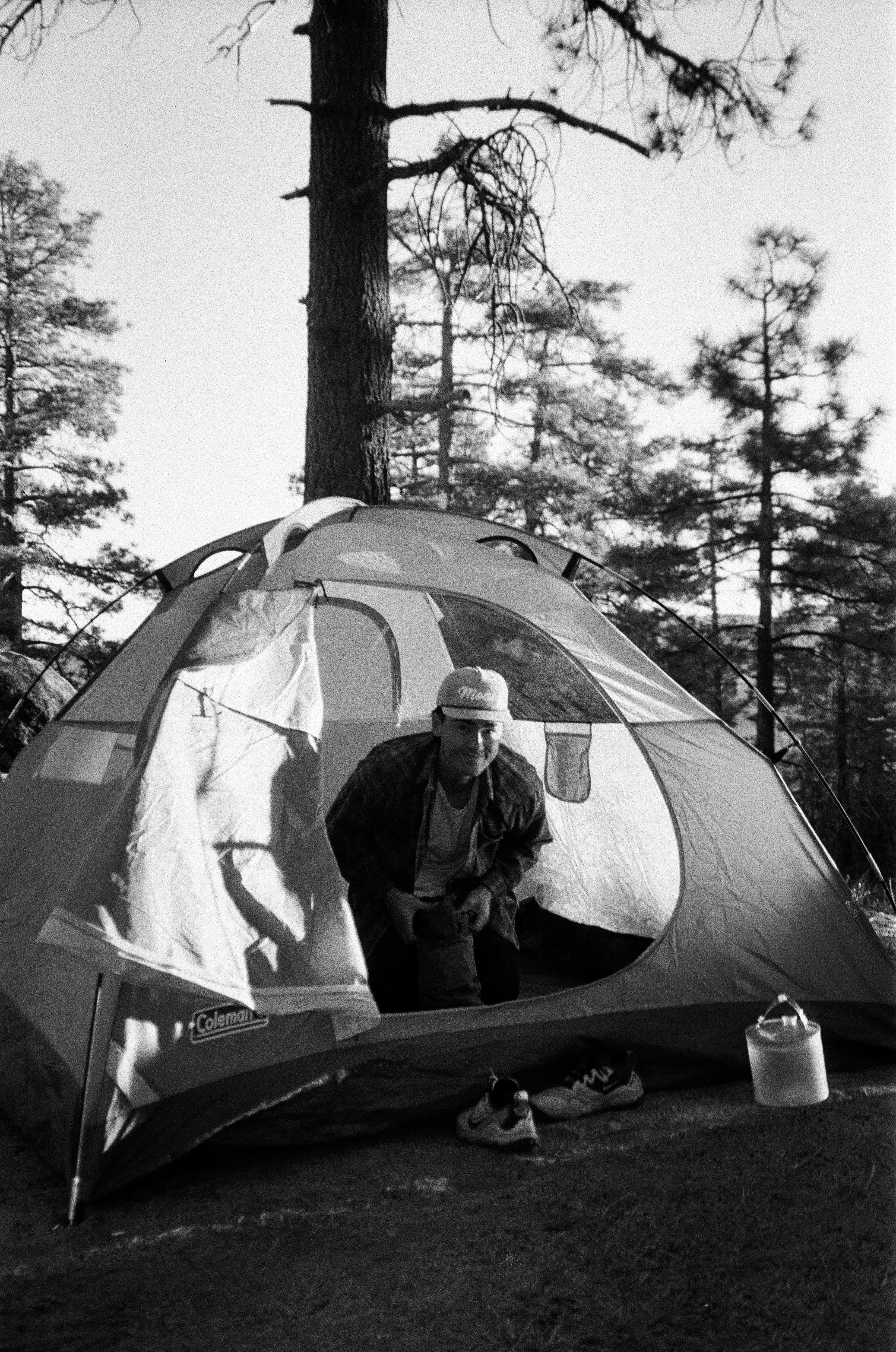 Kodiak Richards at a campsite in the forest, black and white film photograph